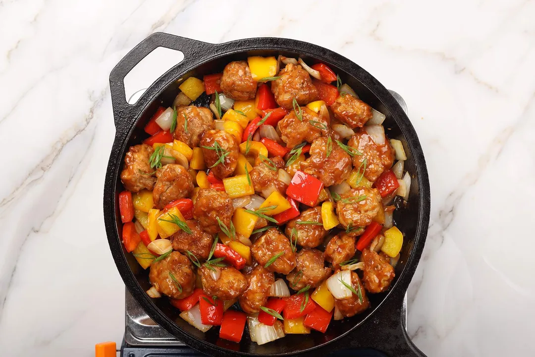 a cast iron skillet of cooked chicken manchurian