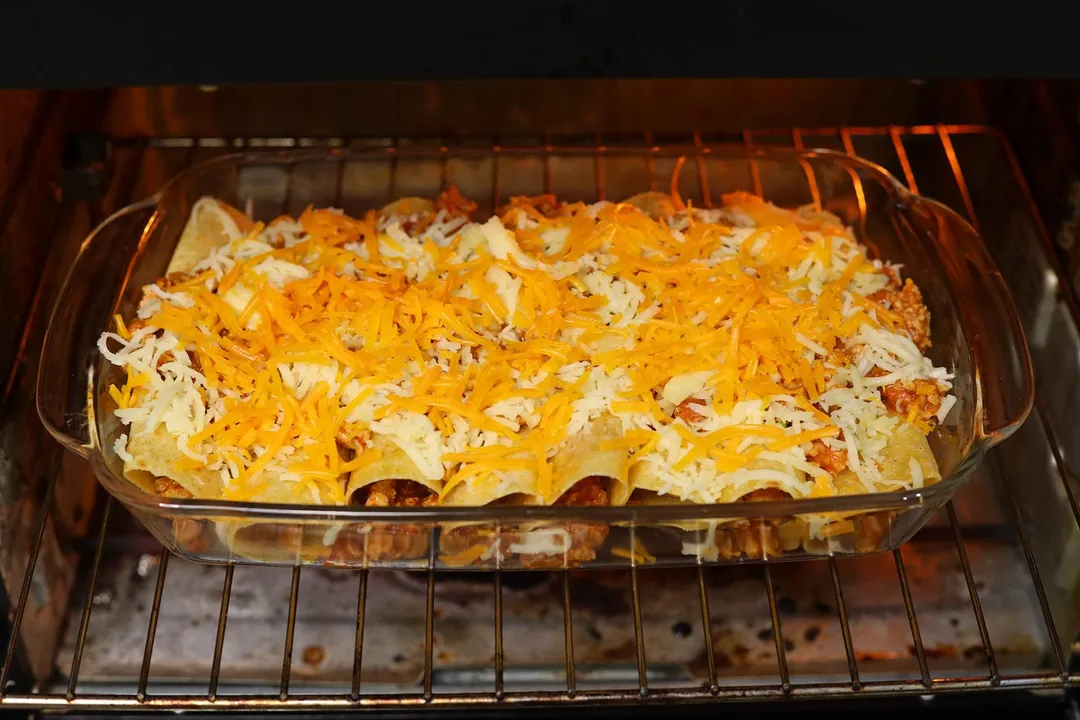 a casserole of ground chicken enchilada baking in an oven