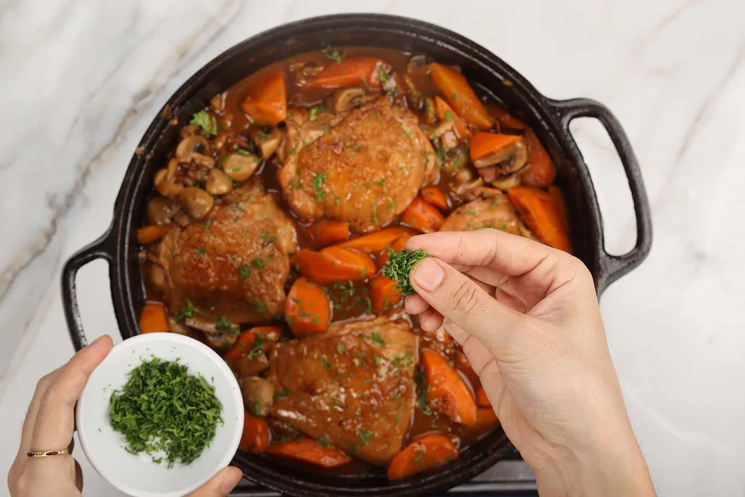 hand sprinkle chopped parsley on top of a cast iron skillet