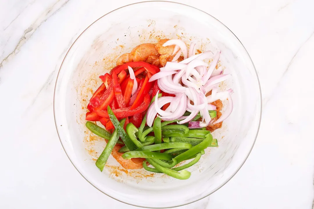 veggies marinate with chicken in a bowl