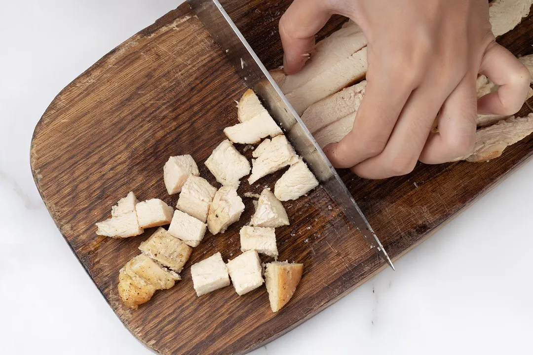 cutting chicken breast on a cutting board