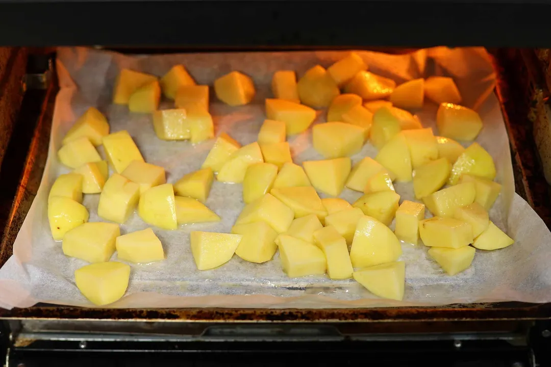potato cubes in a baking tray in an oven
