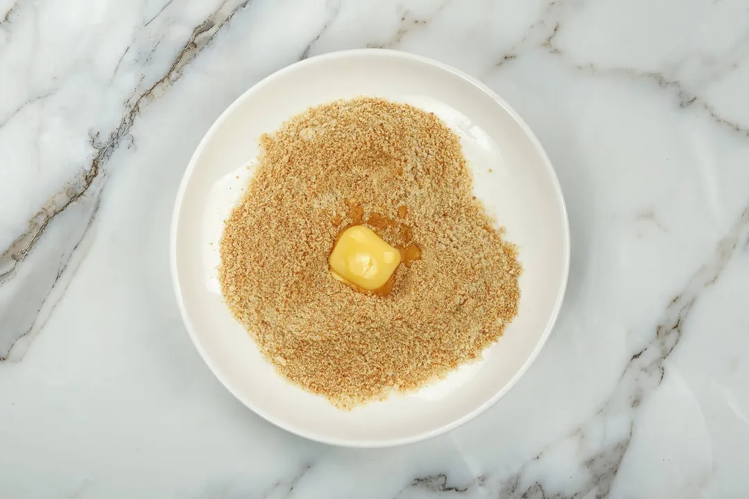 unsalted butter in a plate of breadcrumbs