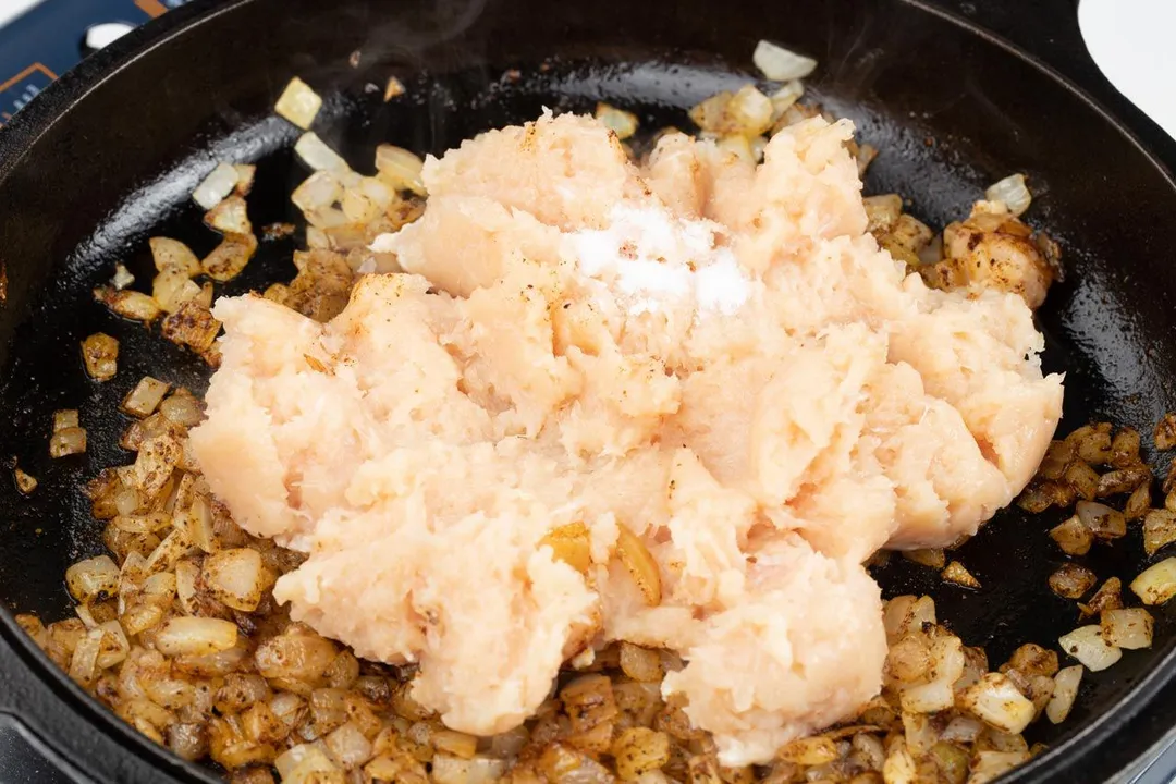 processed chicken and salt in a cast iron skillet