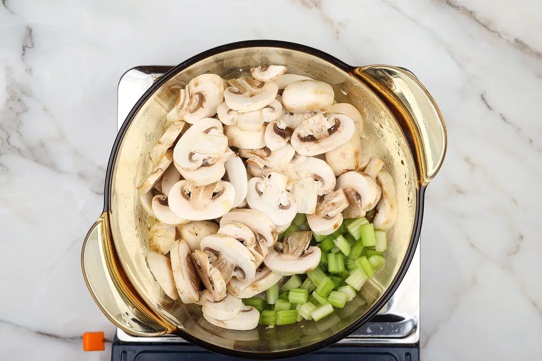 slices mushroom, slices celery in a glass pot