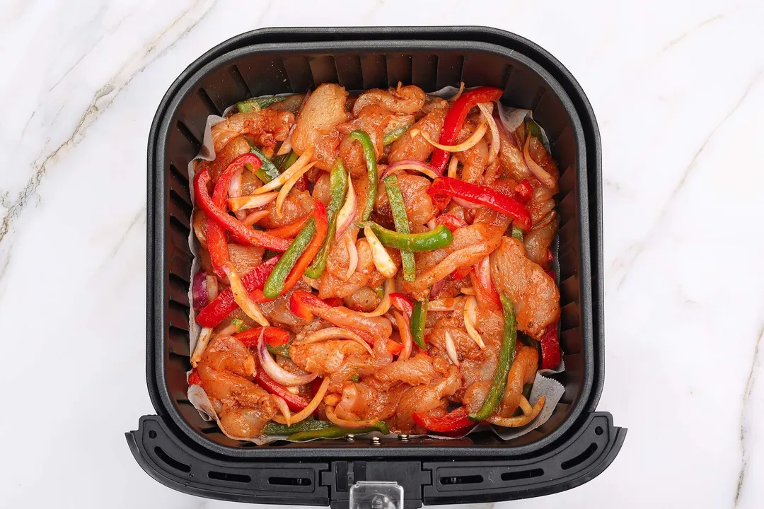 marinated chicken and veggies in an air fryer