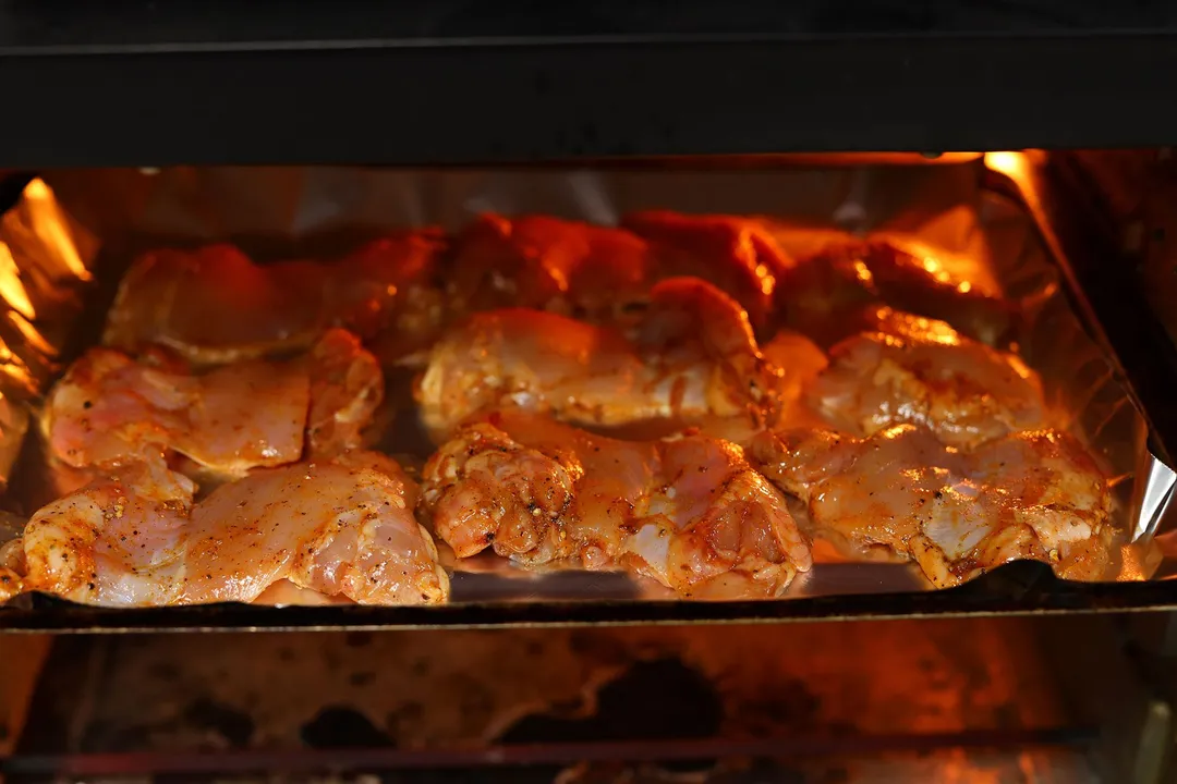 marinated chicken thighs broiling in the oven