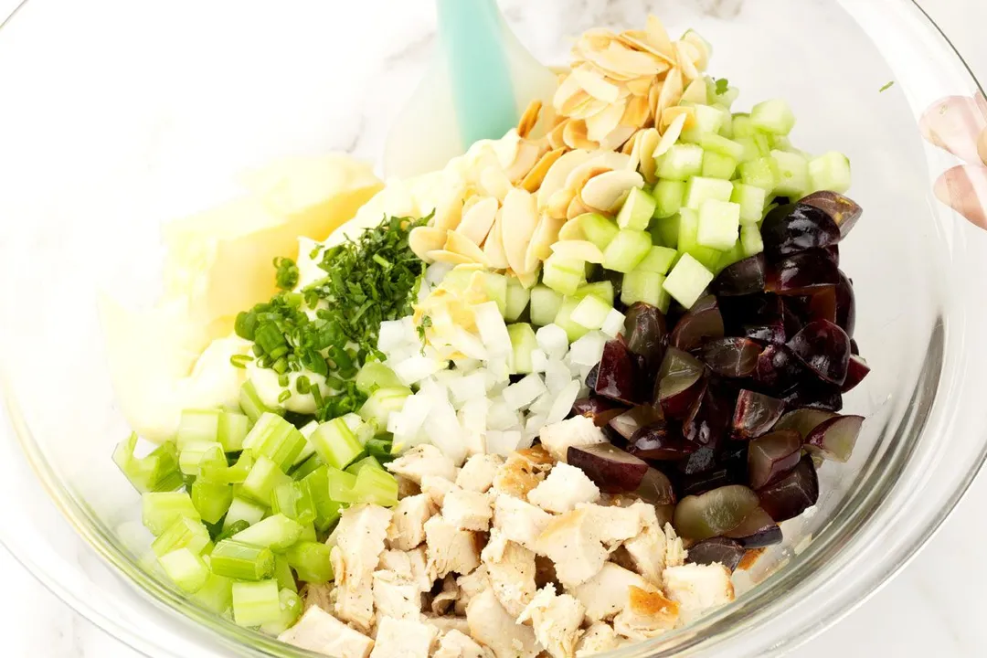 chicken cubed, halved grapes, diced celery, diced cucumber, sliced almond and chopped scallion in a bowl