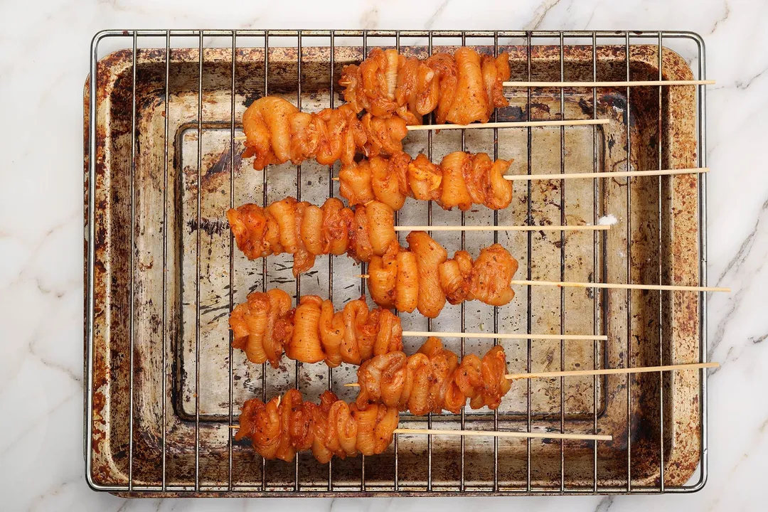 Assemble chicken onto bamboo skewers on a baking sheet