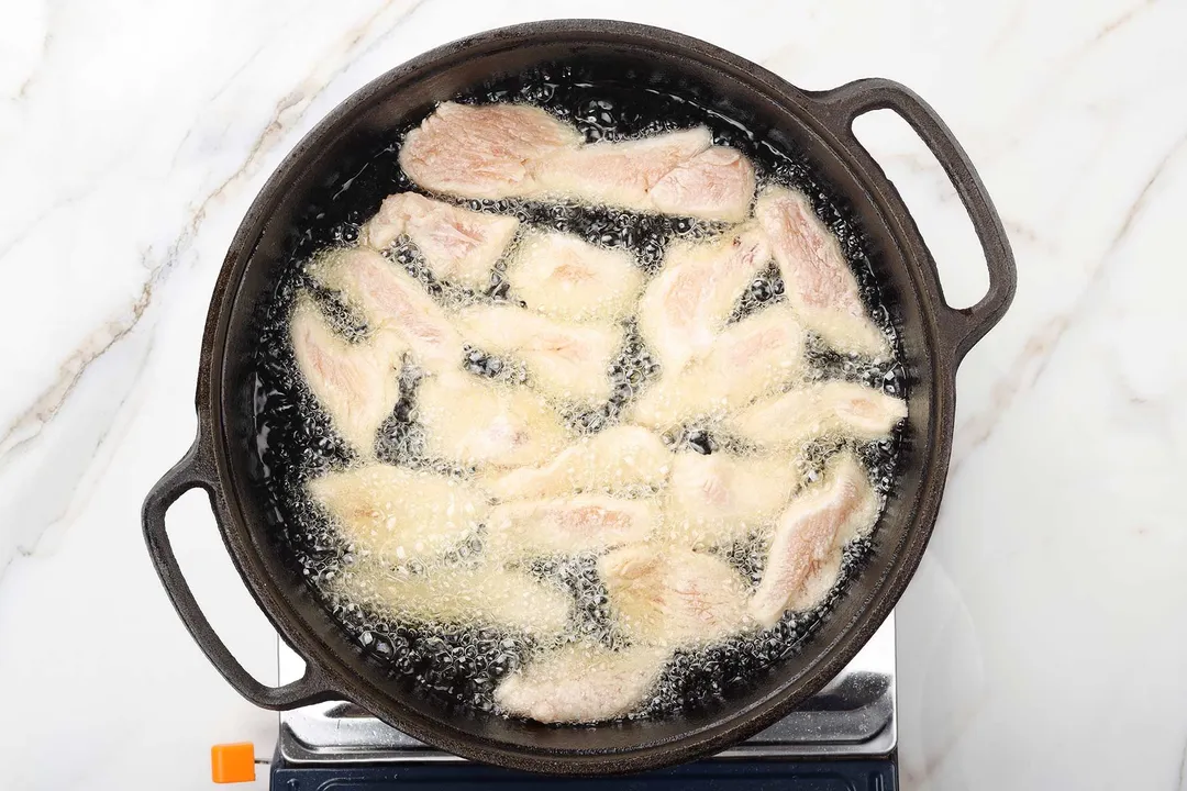 frying coated chicken in a cast iron skillet