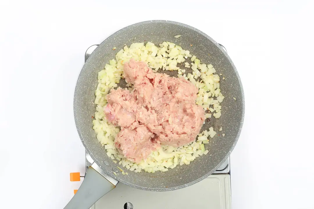 Ground chicken being cooked with garlic in a pan