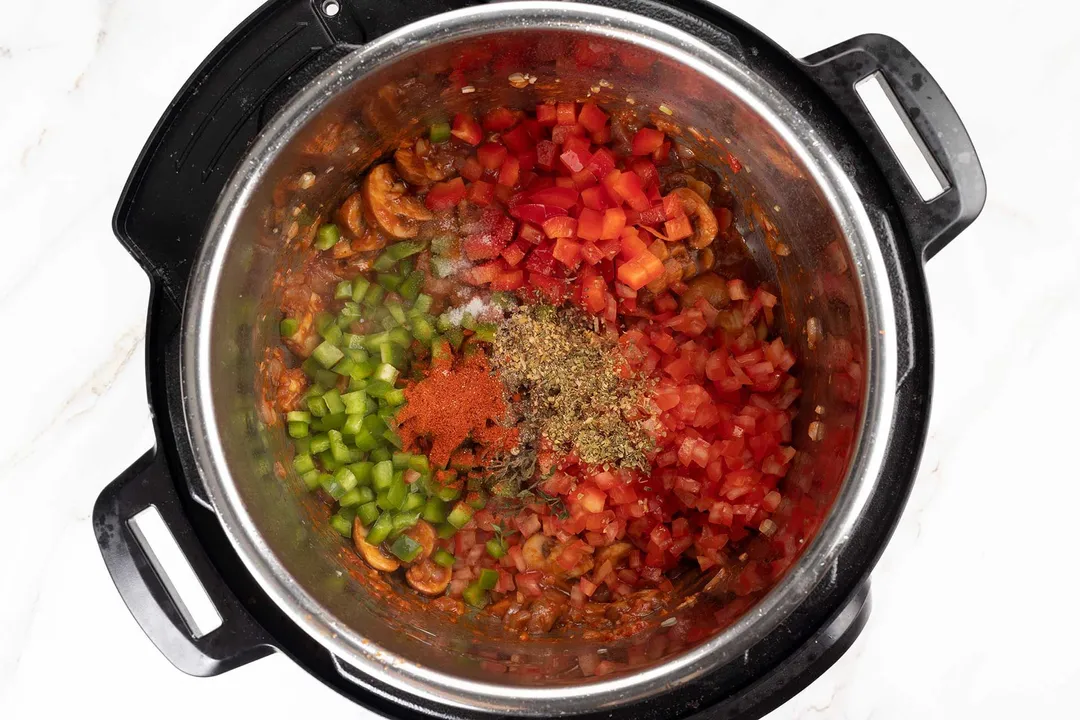 chopped red and green bell pepper and seasoning in an instant pot