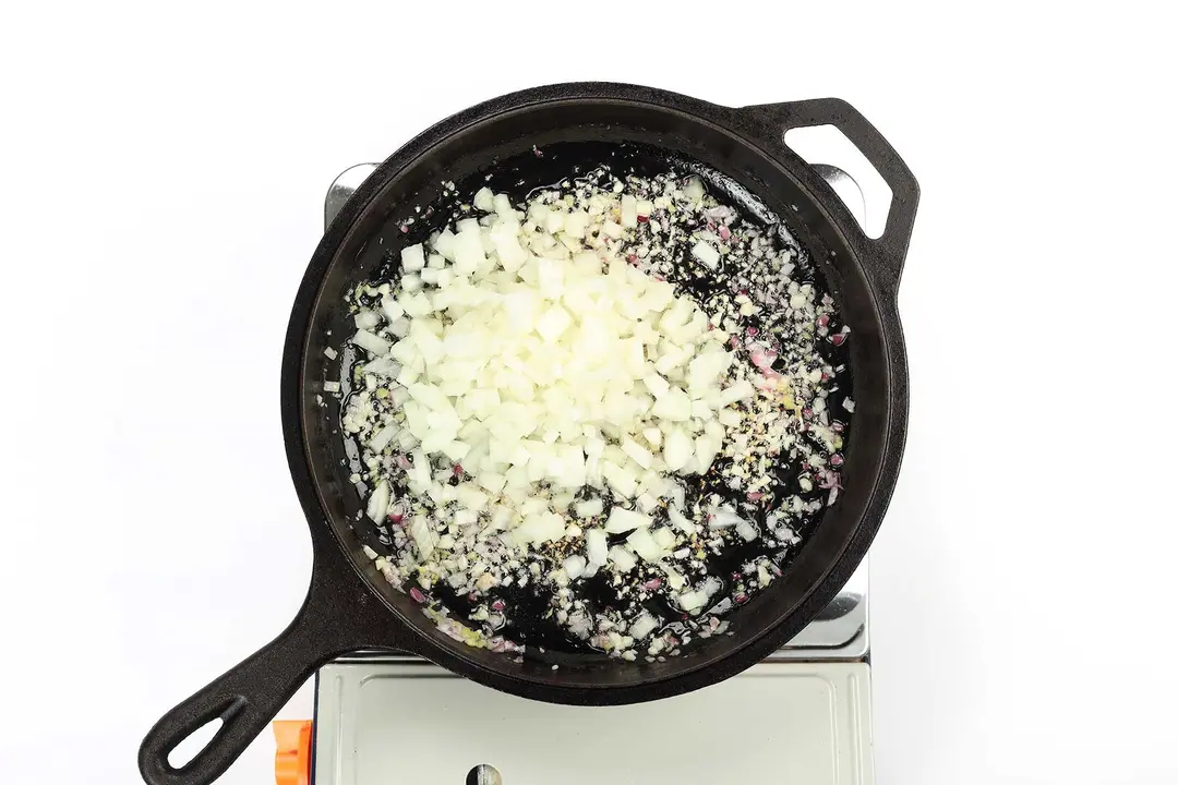 A skillet cooking diced onion
