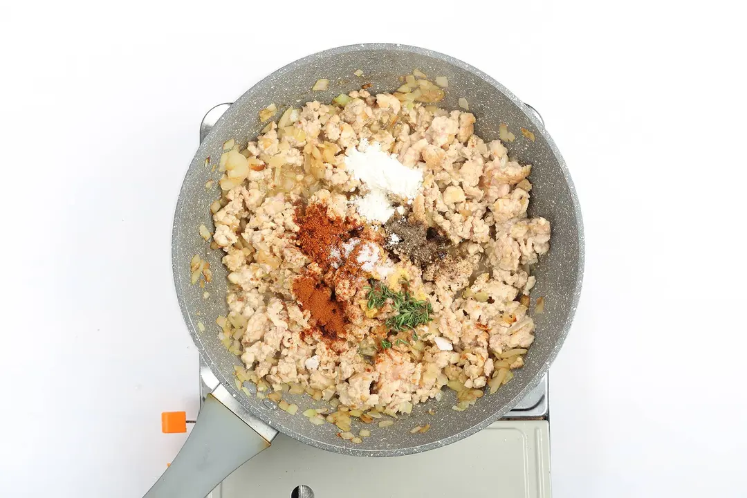 Ground chicken with seasonings in a pan
