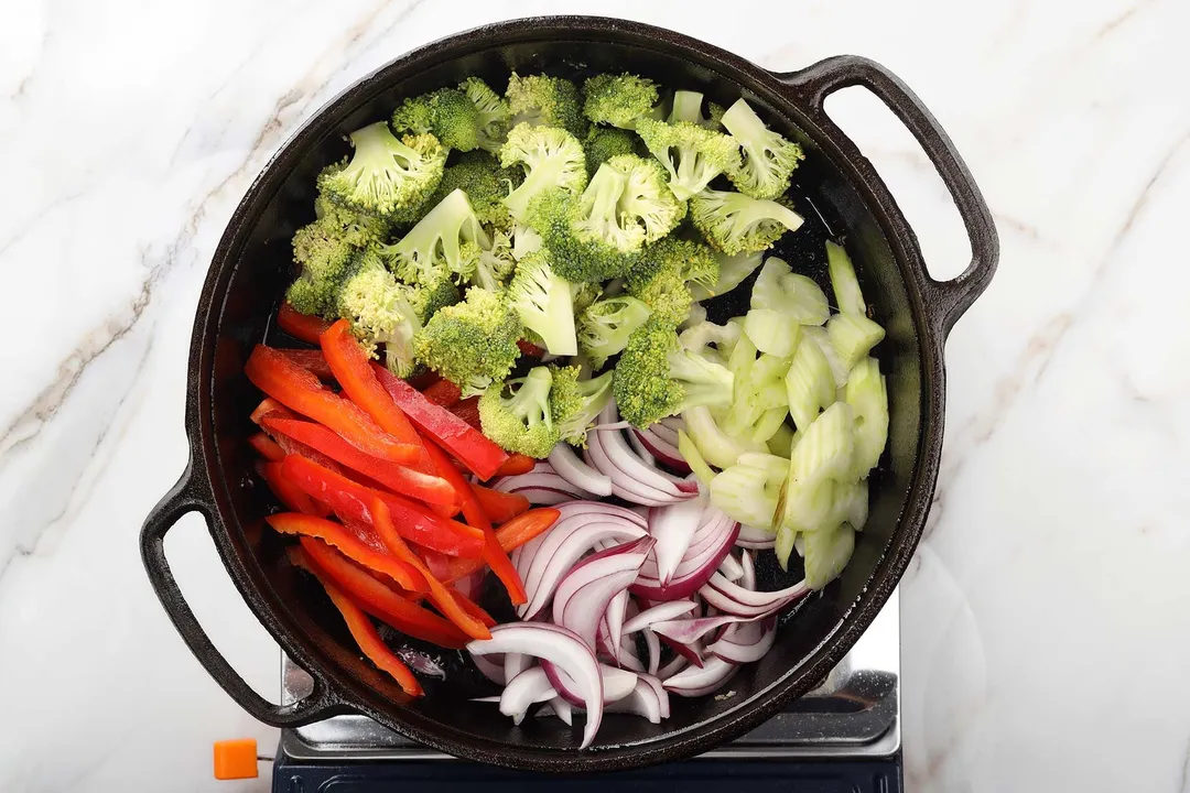 broccoli florets, slices red bell pepper, onion and celery in a cast iron skillet