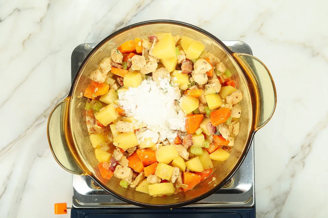 flour, potatoes cubed, carrot and chicken in a pot
