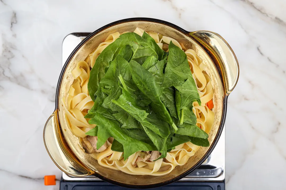 top view of spinach and noodle in a pot
