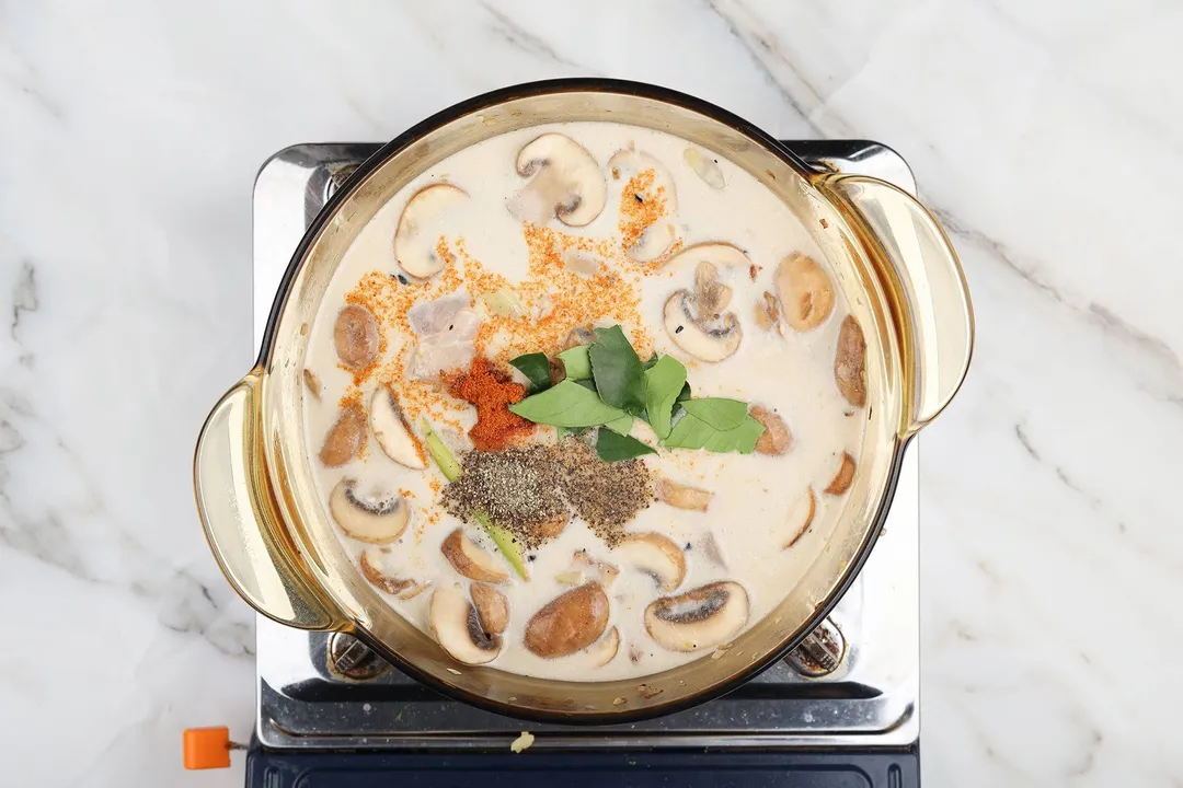 cooking tom kha soup with mushroom, seasoning in a pot