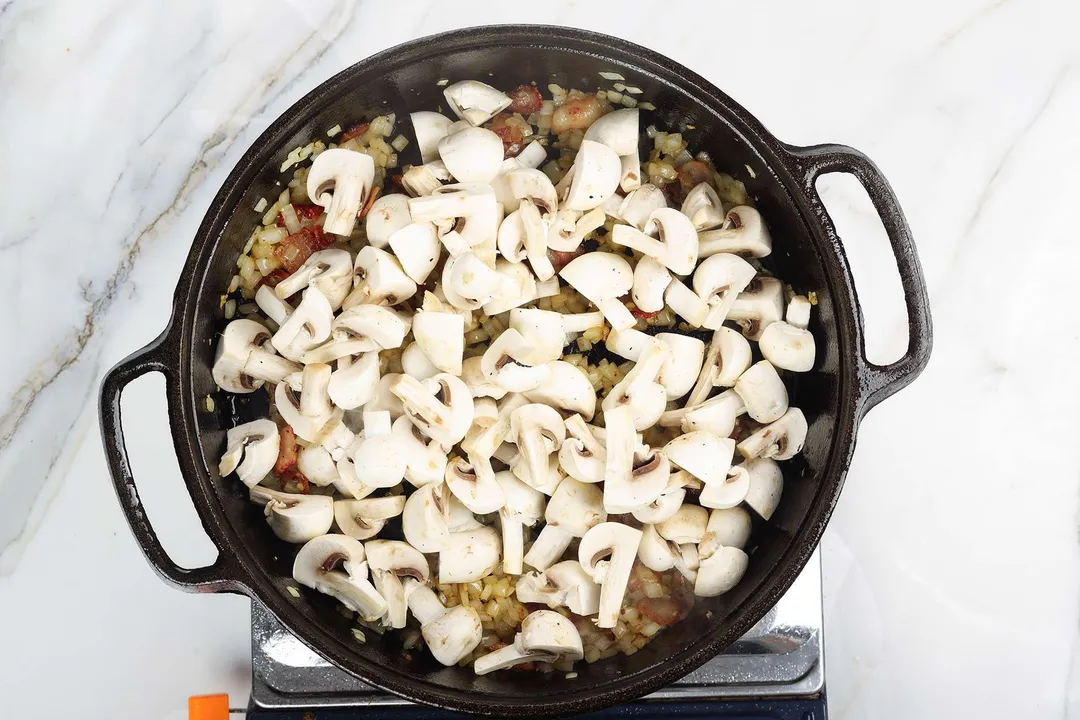 chopped mushroom cooking in a cast iron skillet
