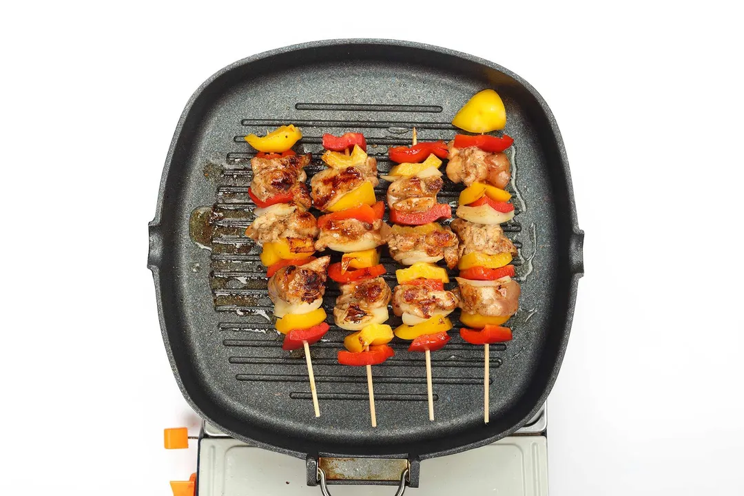 Chicken skewers in a cast iron skillet