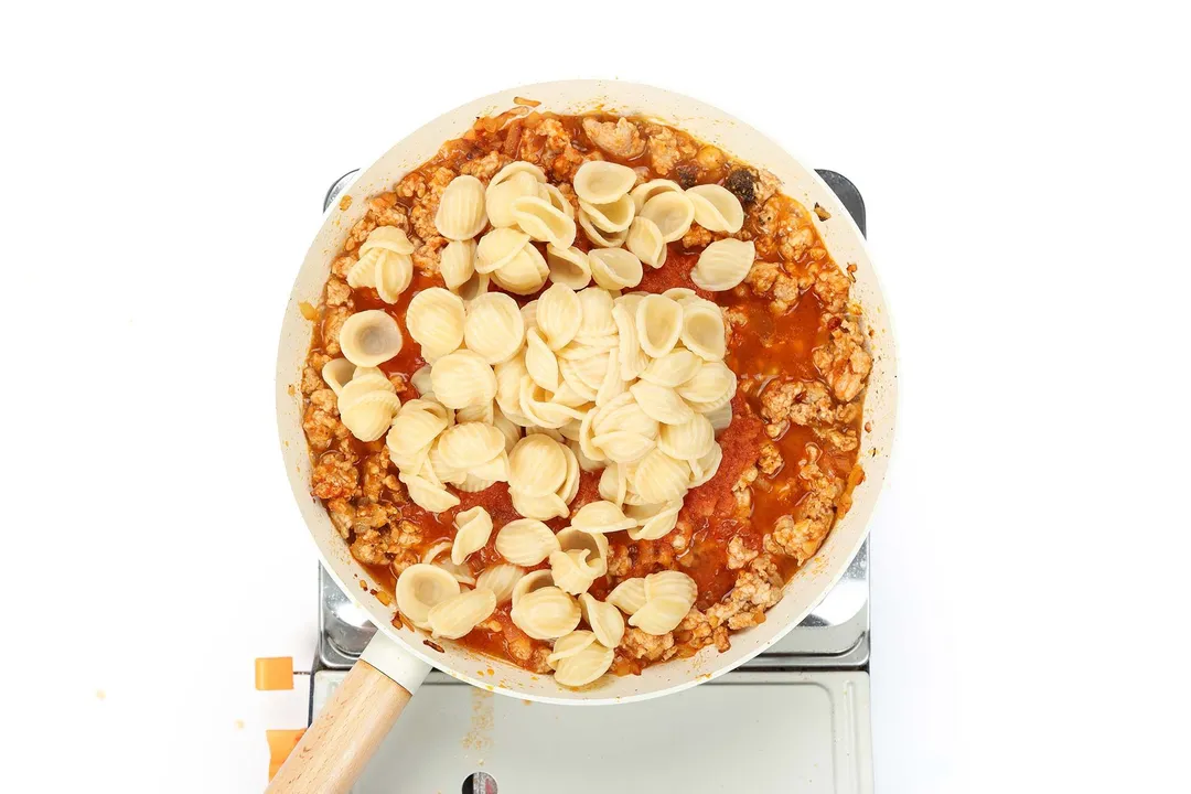 pasta and ground chicken cooking in a skillet