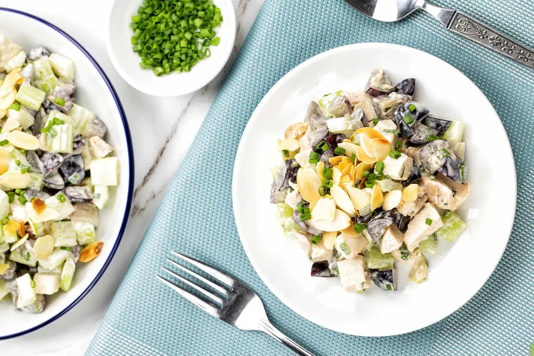 two plate of grape chicken salad and a small bowl of chopped scallion