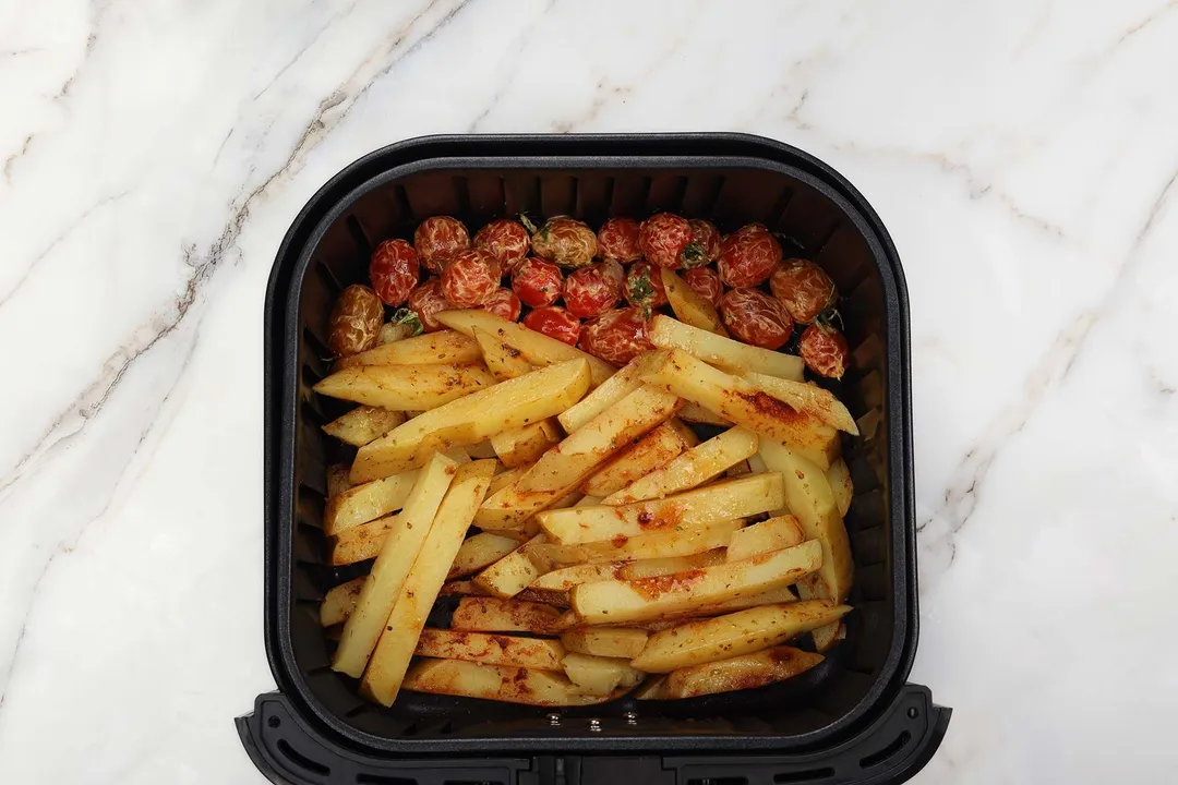 potatoes batonnet and cherry tomatoes in air fryer basket