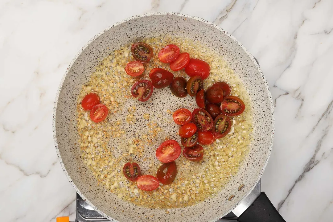 cherry tomato cooking in skillet