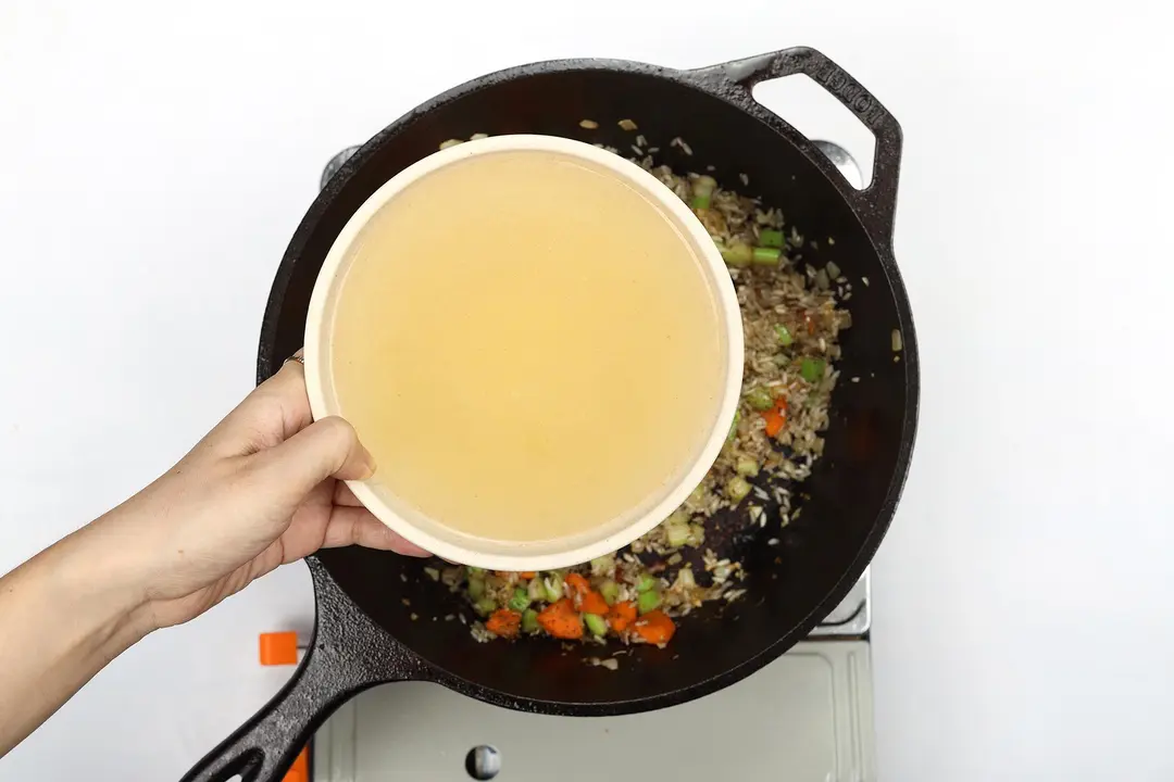 Chicken broth being added to the skillet