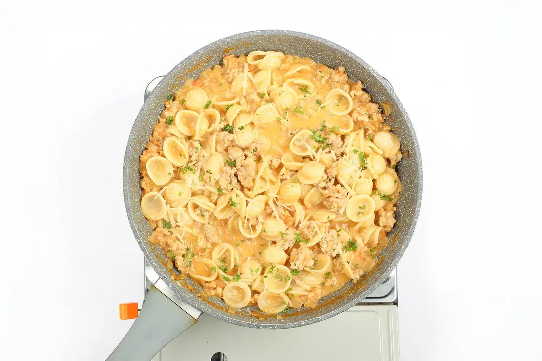 Ground chicken pasta in a pan garnished with parsley