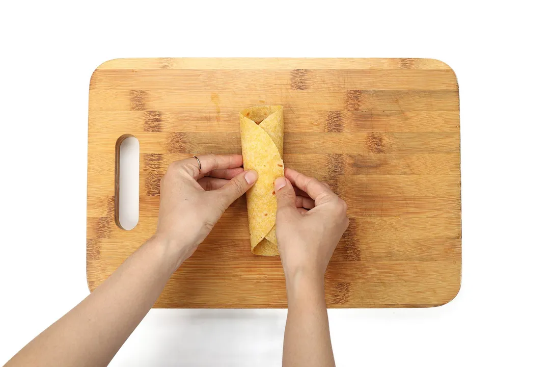 rolling tortilla on a cutting board