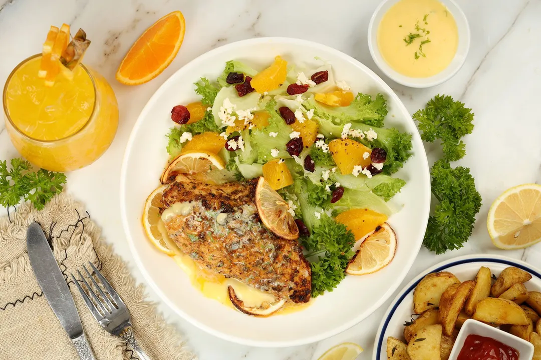 top view of a plate of cooked chicken breasts and salad