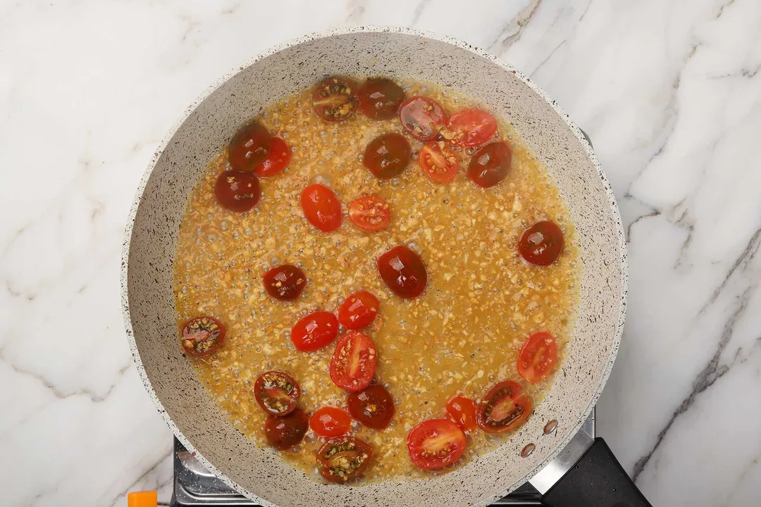 cooking tomato with sauce in a skillet