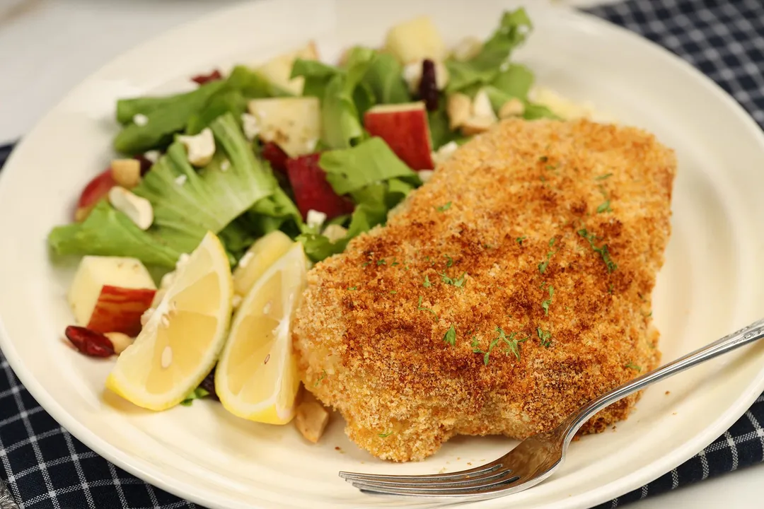 a plate of cooked chicken breast and salad