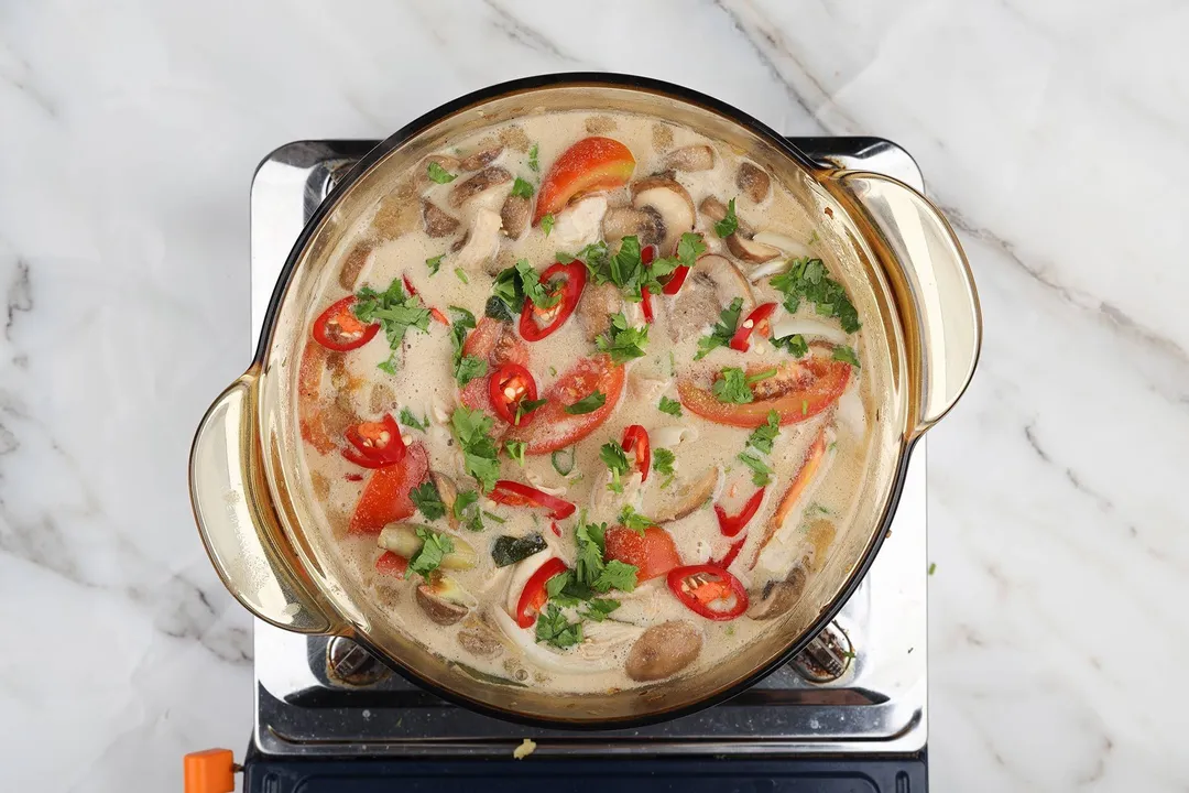 a pot of cooked tom kha soup on a gas stove