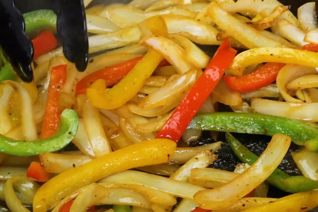 Stir fry the vegetables for chicken fajitas