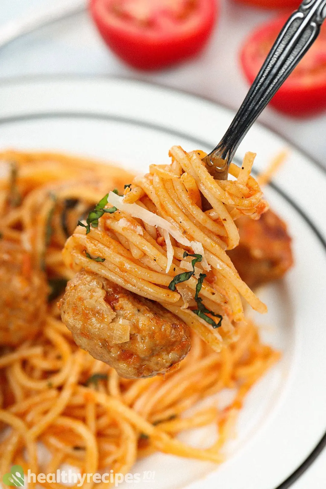 A chicken meatball with spaghetti on a fork