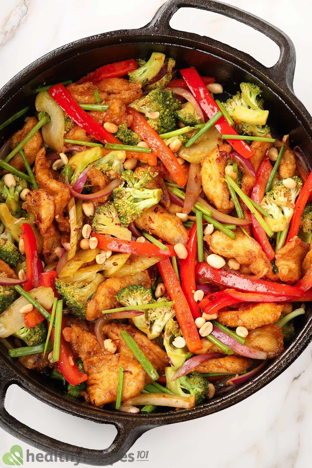 top view of a cast iron skillet of cooked chicken and vegetables