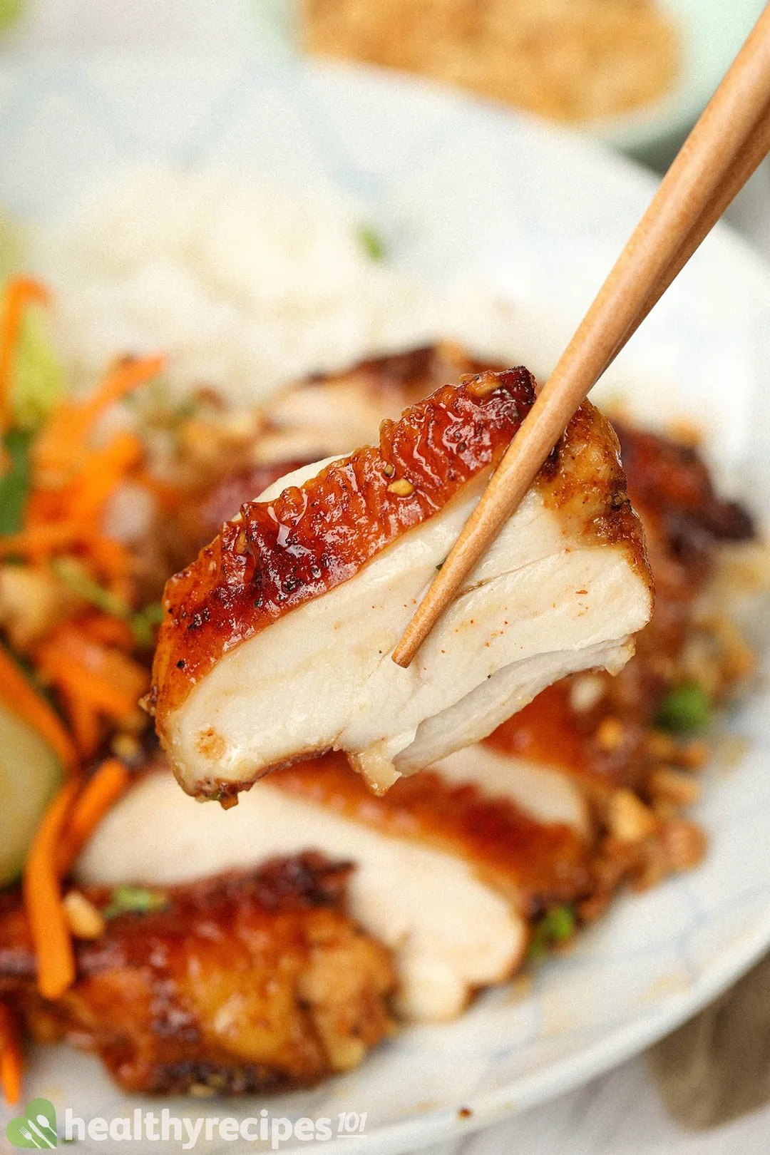 A small piece of Thai chicken held by chopsticks