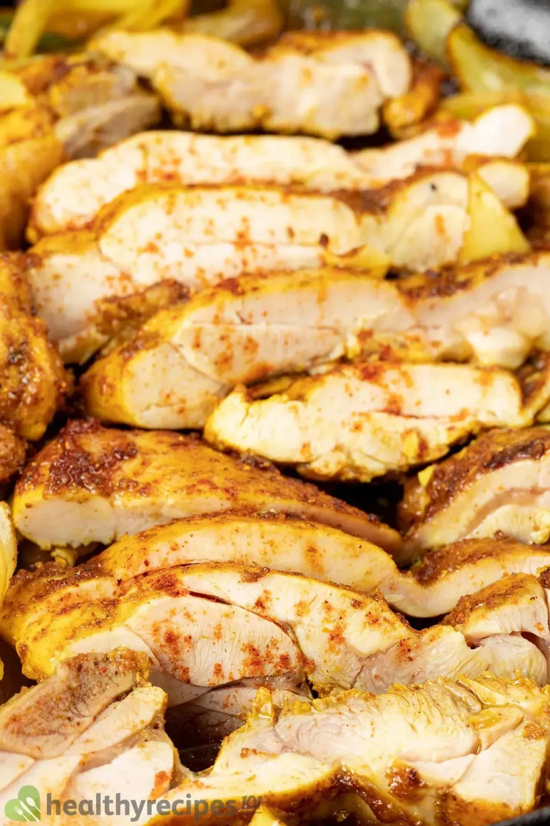A close-up shot of cut-up chicken shawarma speckled with spices