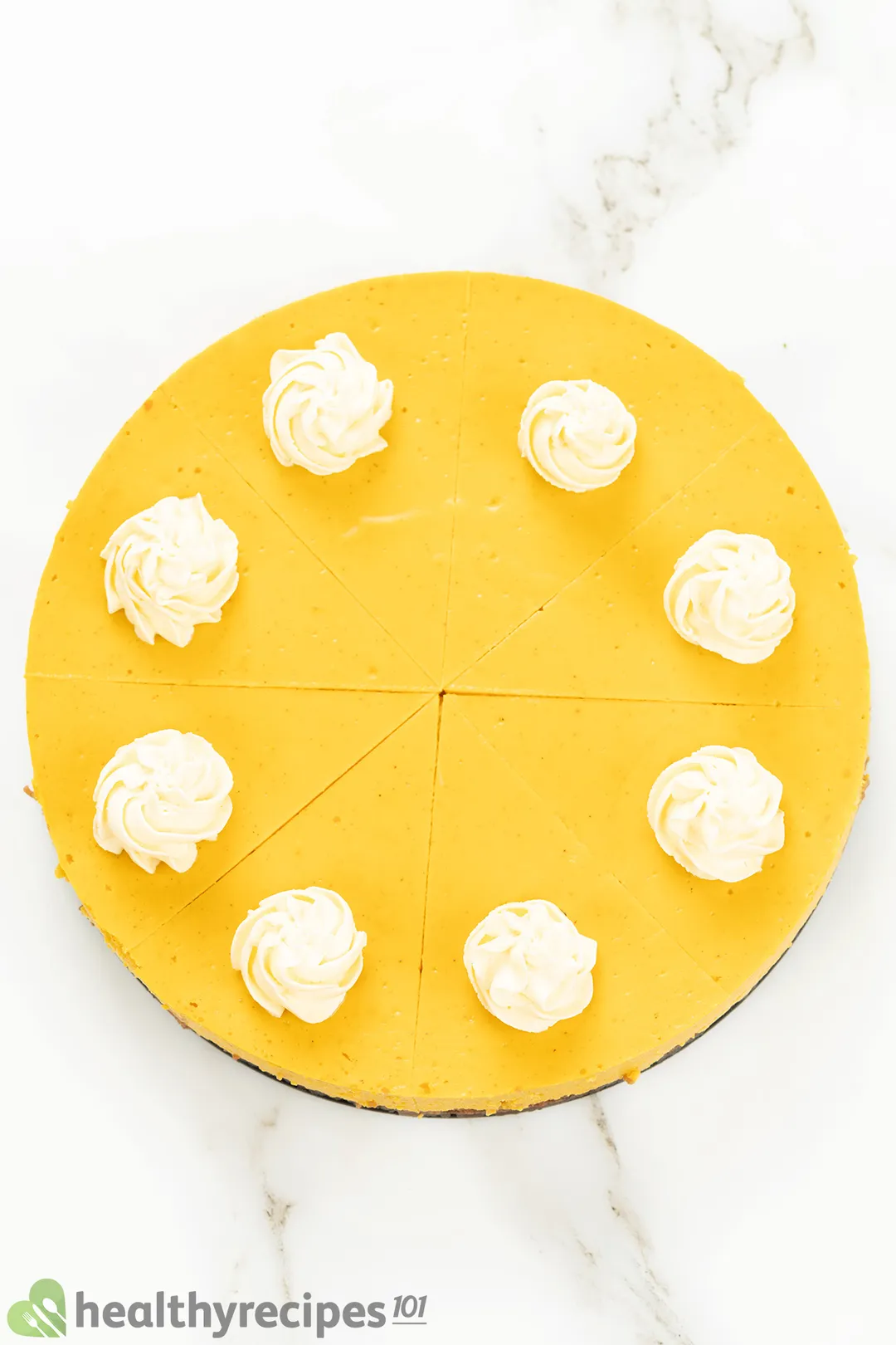 top view of a pumpkin cheesecake with cream on surface