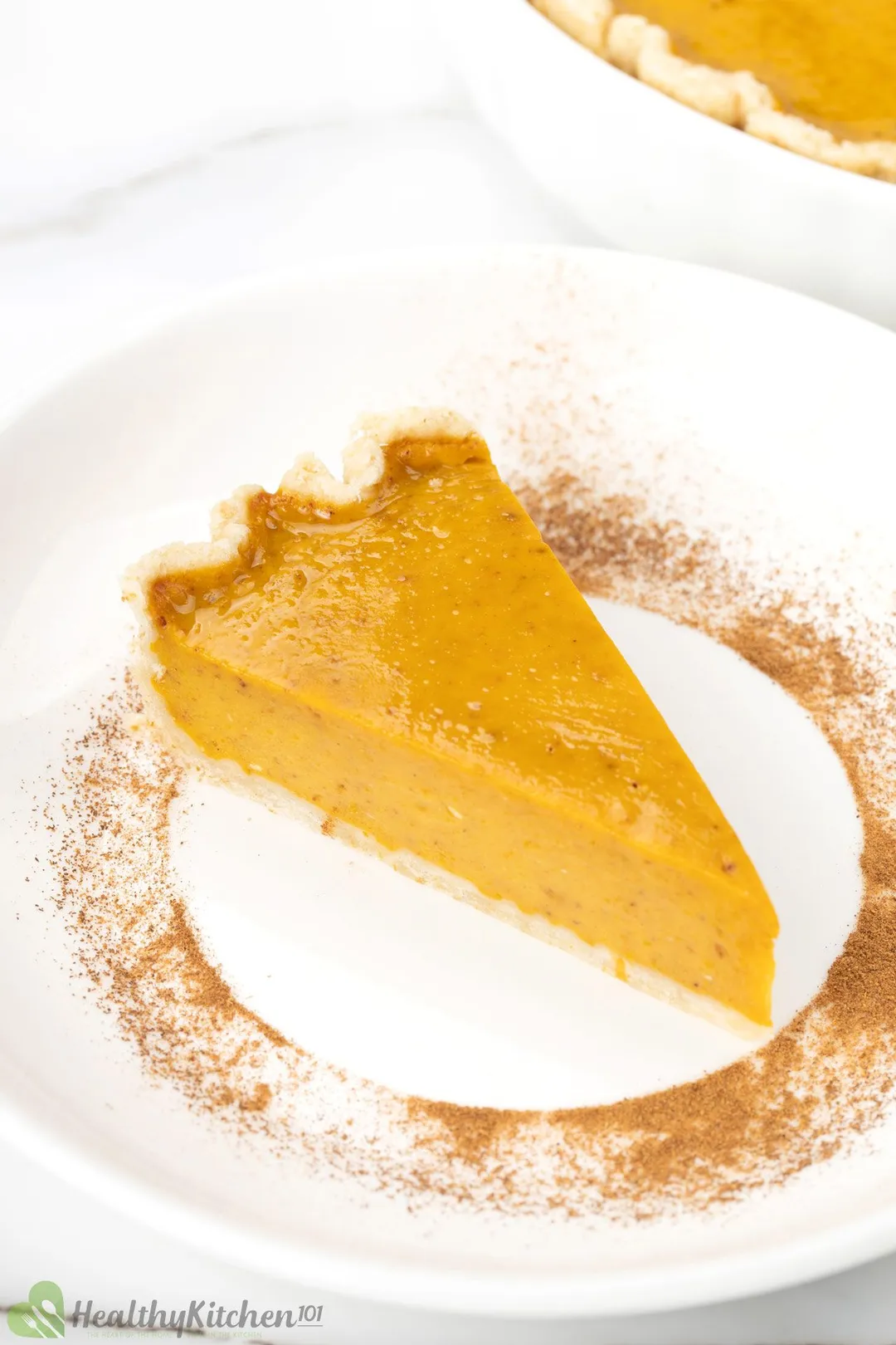 A slice of pumpkin pie on a white plate.