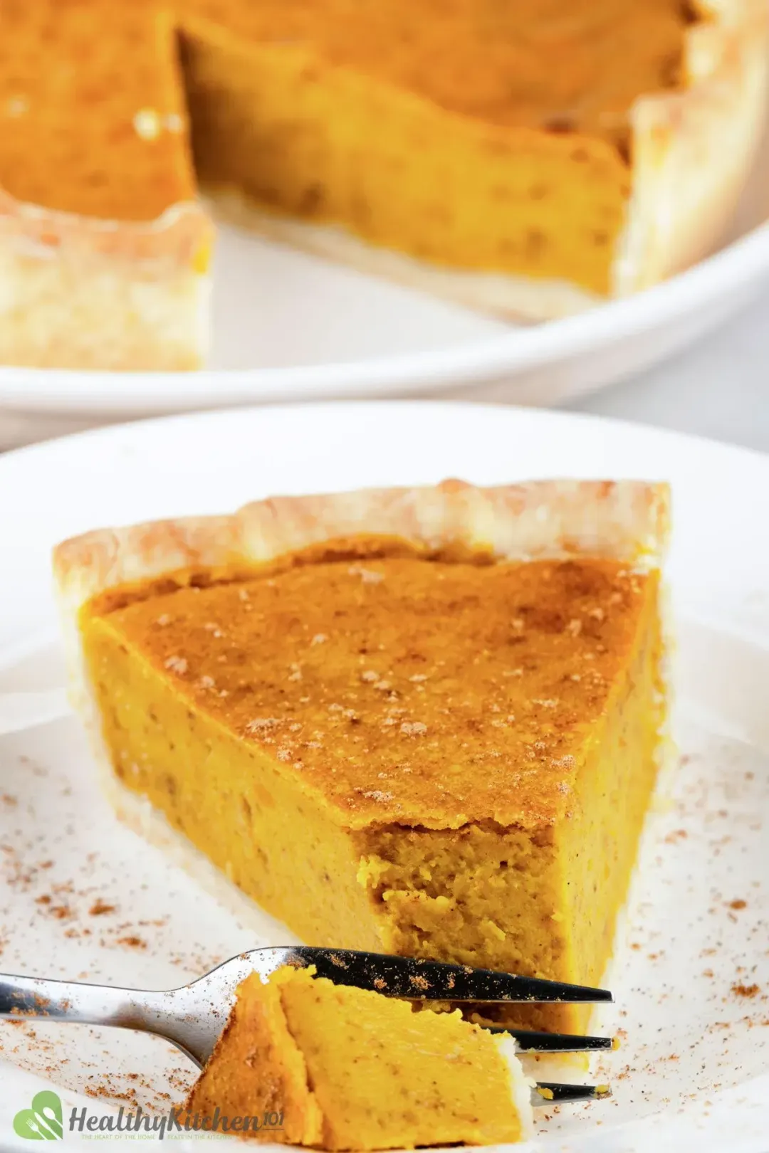 A fork slicing into a piece of pumpkin pie