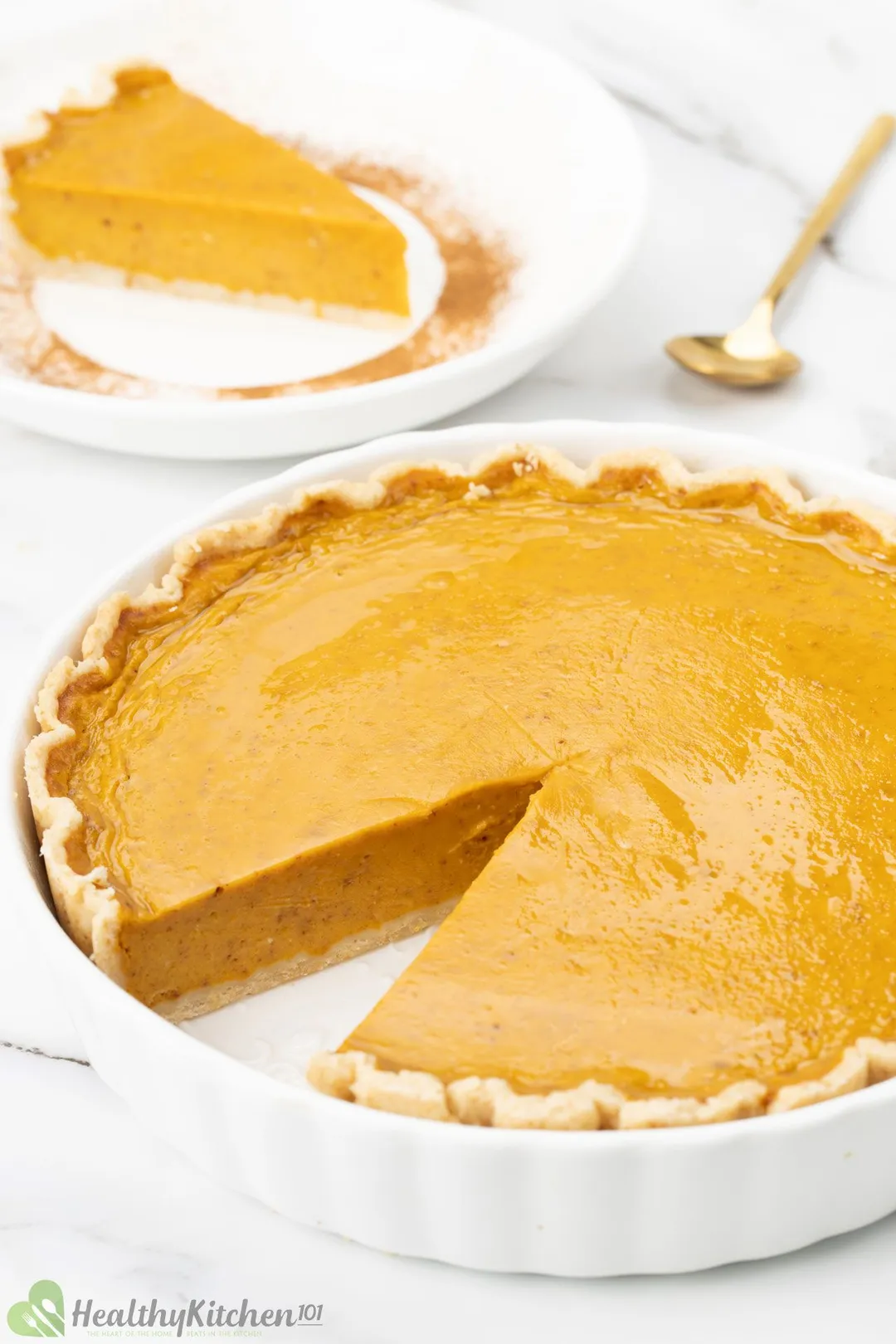 A pumpkin pie with a slice cut out