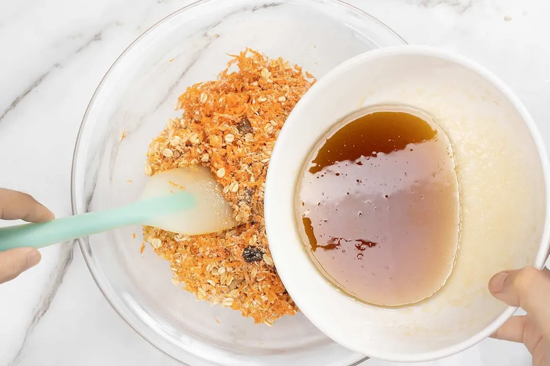 pouring a bowl of wet ingredient to a glass bowl of dry ingredients