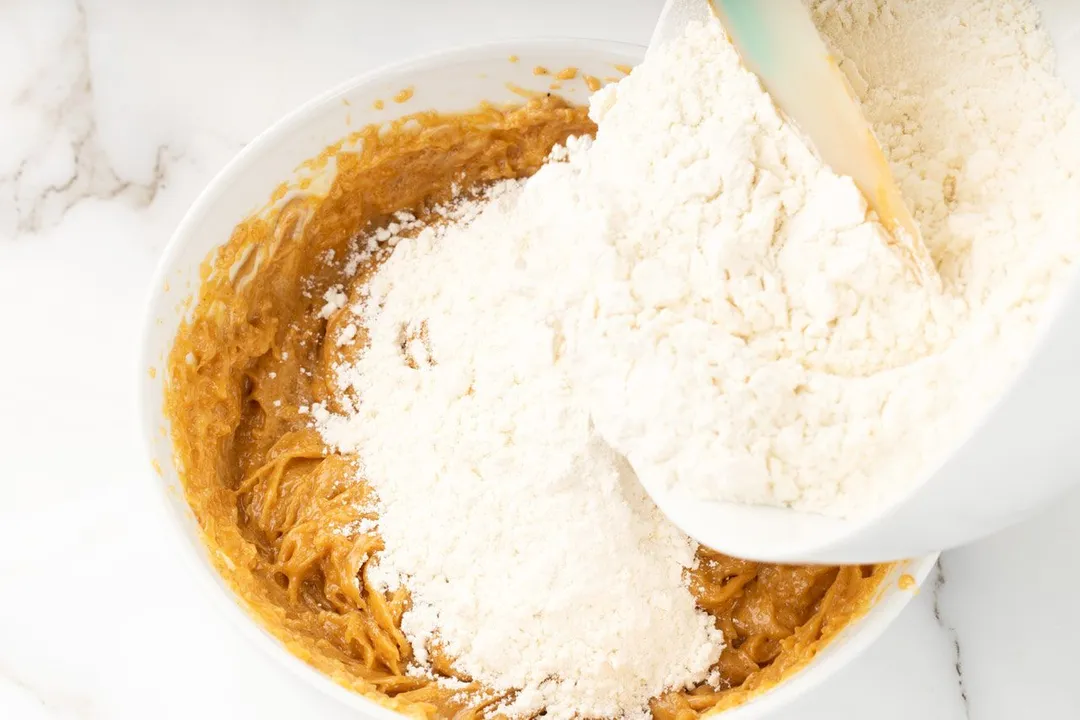 pouring flour from a bowl to another bowl