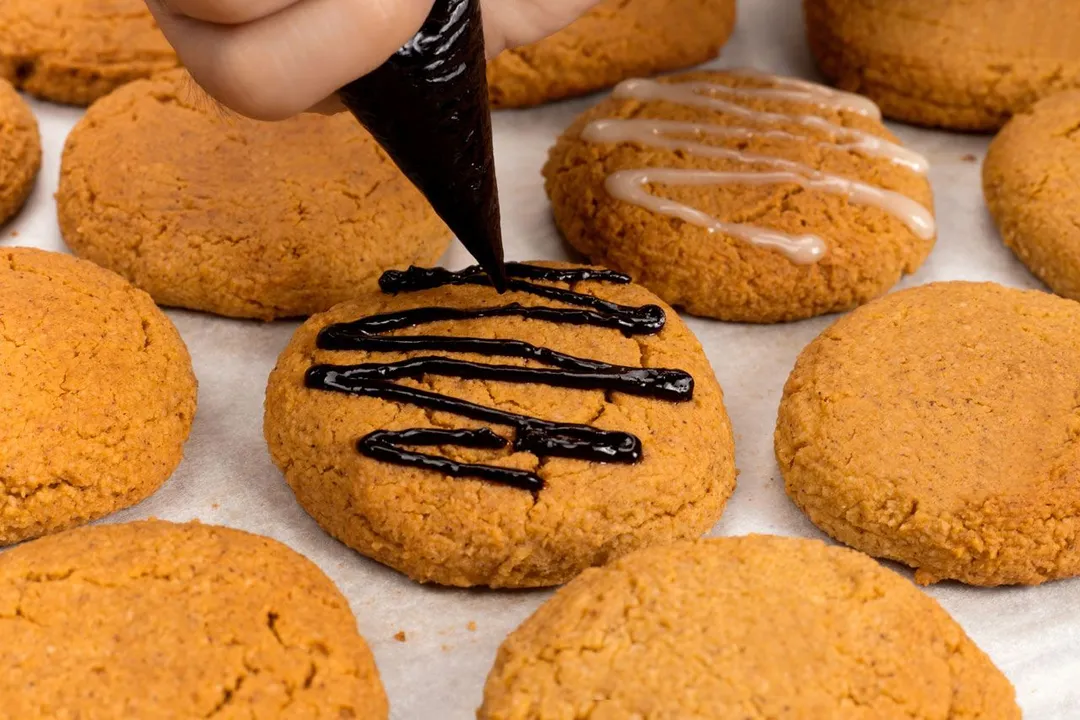 decorating pumpkin cookies with dark chocolate