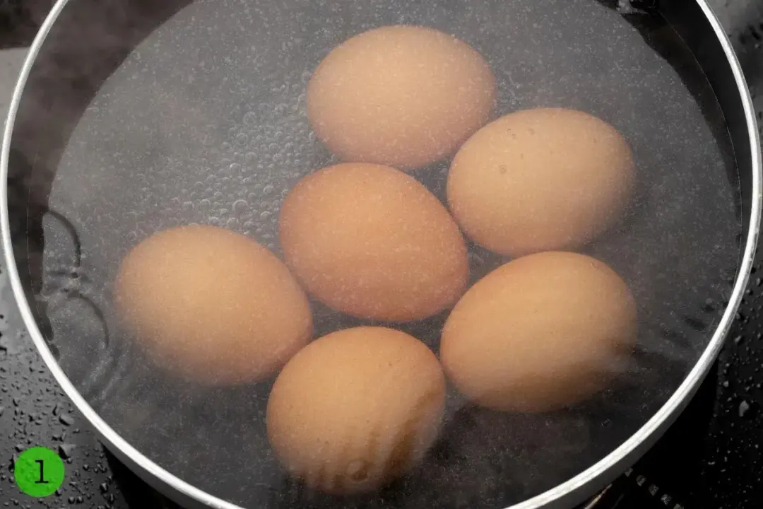Six eggs submerged in a pot of water