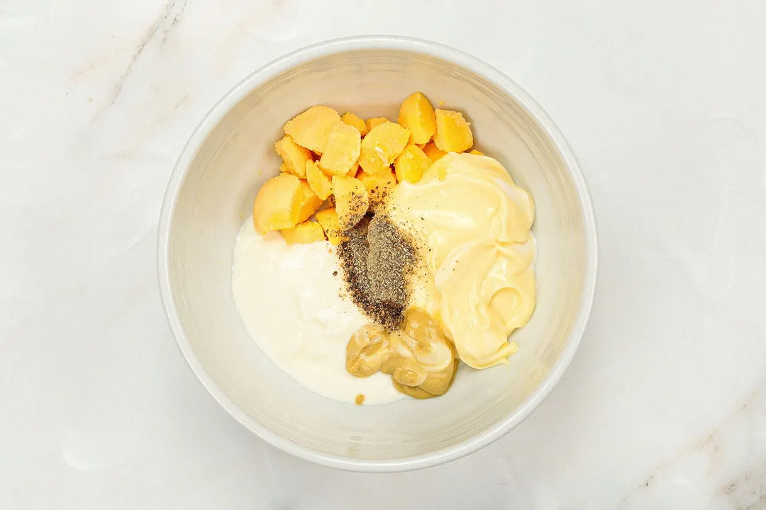 mayonnaise, egg yolks, yogurt pepper and mustard in a bowl