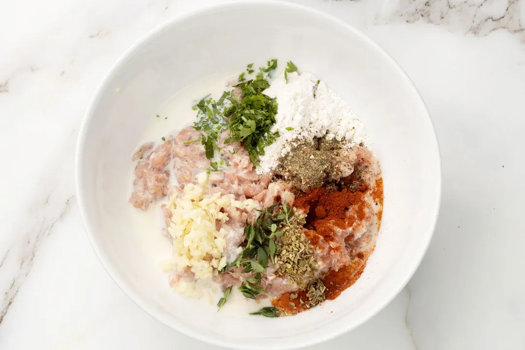 ground pork, flour and seasoning in a bowl